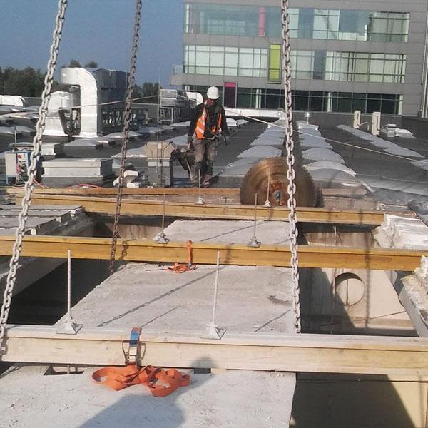 Robotnik na dachu rozbieranego budynku